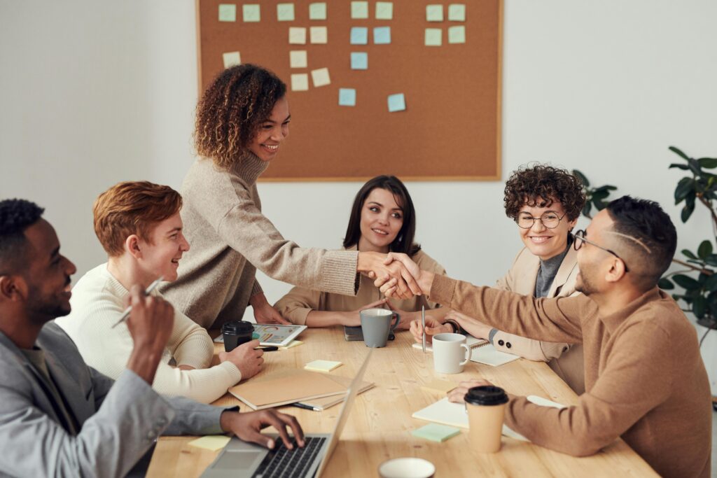 Projetos Diverse team collaborating in a meeting, showcasing teamwork and cooperation in a modern workplace.