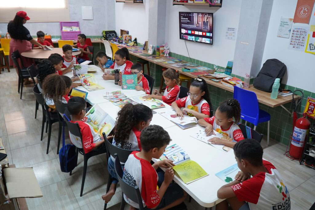 Projetos Children engaged in reading at a community library in Glória do Goitá, Brazil.